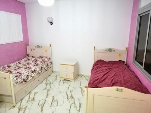 的住宿－Ferme salam，一间卧室设有两张床和紫色墙壁