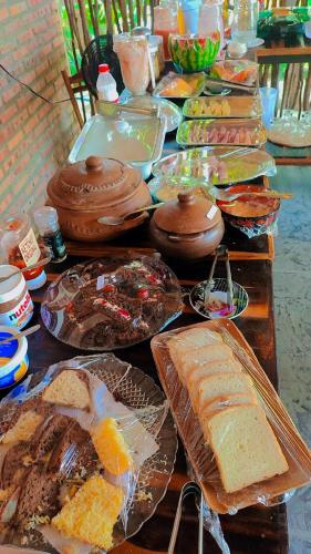 a table topped with lots of different types of bread at Chalés da Cris in Fortim