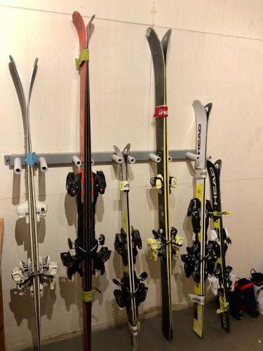 a bunch of skis are hanging on a wall at Maison Etoile - Pila n 0042 in Pila