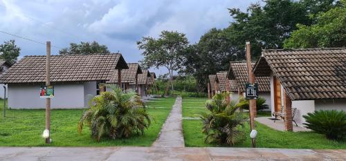 a row of cottages with palm trees in the yard at Pousada Beira da Mata-Jalapão in Mateiros