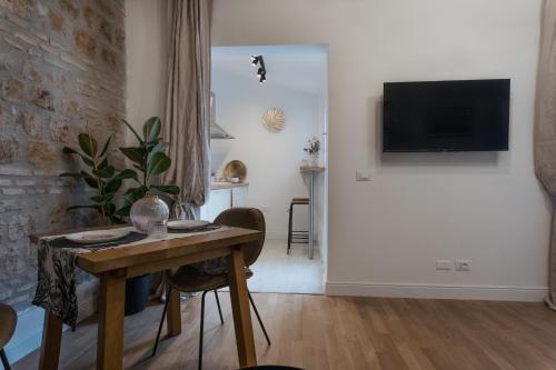 een woonkamer met een tafel en een tv aan de muur bij la polveriera, appartamenti eleganti e luminosi vicino al Colosseo in Rome