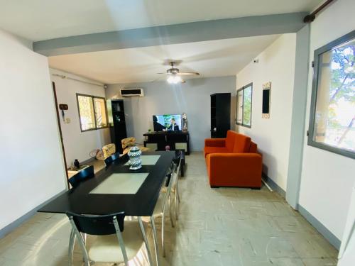 uma sala de estar com uma mesa e um sofá laranja em House G&S, depto con 3 dormitorios para 7 personas pleno centro de la ciudad em Puerto Iguazú