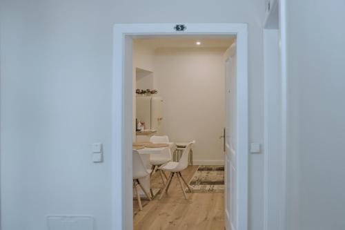 a hallway with a table and chairs in a room at Pink Lotus Apartment in Vienna