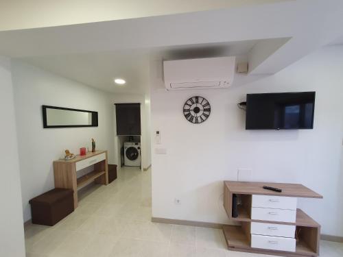 a living room with a desk and a clock on the wall at Summer House in São Martinho do Porto