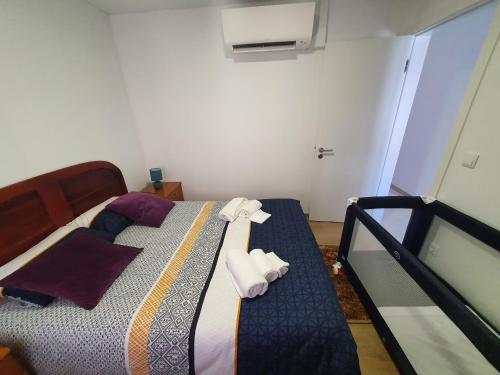 1 dormitorio con 1 cama con toallas en Holidays House, en São Martinho do Porto