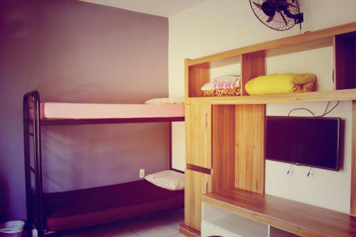 a room with a bunk bed and a tv at Hostel Nossa Casa in Florianópolis