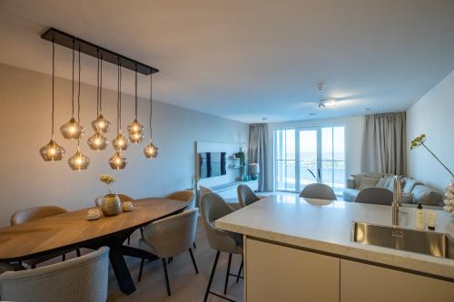 a kitchen and living room with a table and a dining room at The Sailor, full sea view, use of hotel swimming pool and sauna in Cadzand