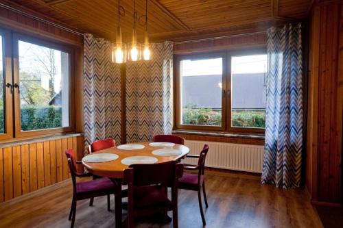 a dining room with a table and chairs and windows at Janosik in Kluszkowce