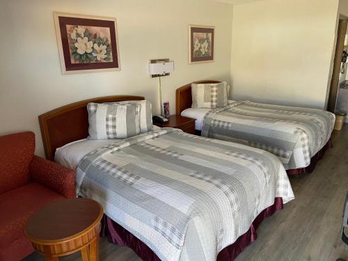 a hotel room with two beds and a chair at Colonial Inn in Shawnee