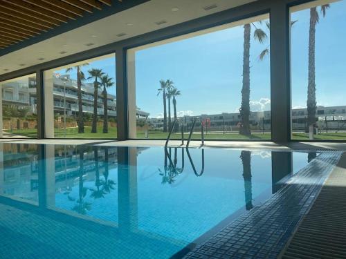 ein großer Pool mit Palmen in einem Gebäude in der Unterkunft Casa cariño in Alicante
