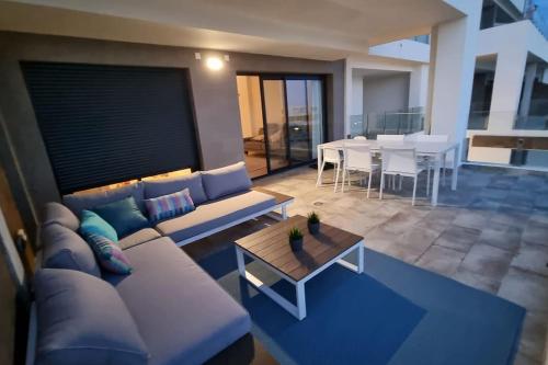 ein Wohnzimmer mit einem Sofa und einem Tisch in der Unterkunft Casa cariño in Alicante