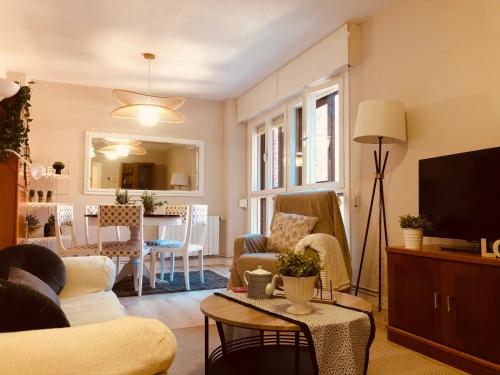 sala de estar con sofá, TV y mesa en Precioso apartamento en Los Castros, en Santander