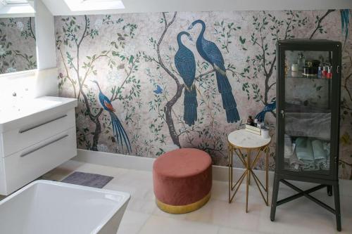 a bathroom with a bird mural on the wall at Hurstpierpoint 3 bedroom House with Hot-Tub & Garden in West Sussex in Hurstpierpoint
