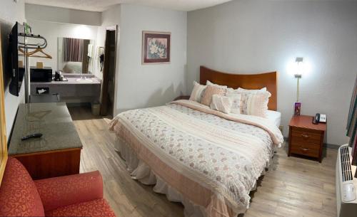 a bedroom with a large bed and a bathroom at Colonial Inn in Shawnee