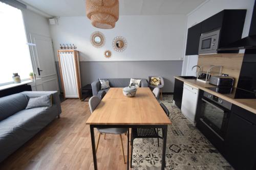 a kitchen and living room with a table and a couch at La Maison du Bonheur - Lille in Lille