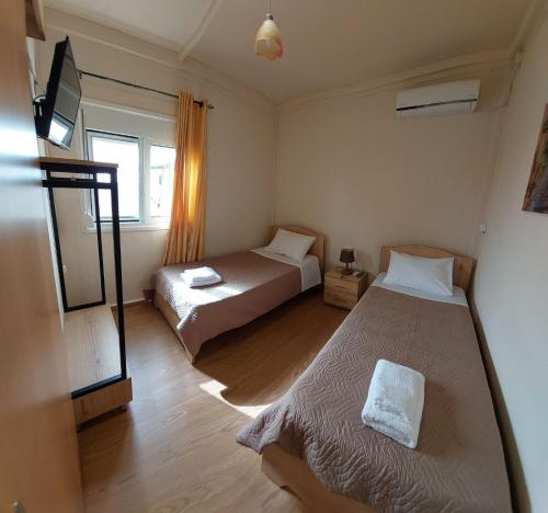 a small room with two beds and a window at Kima House in Kalamaki