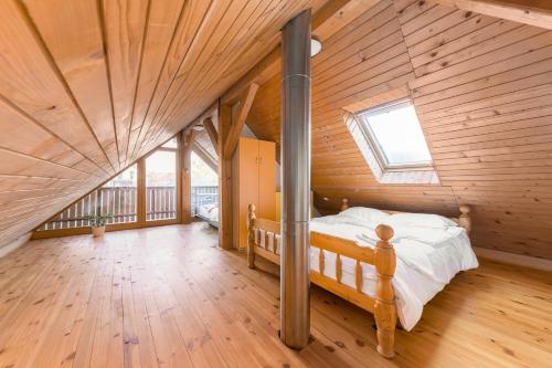 ein Schlafzimmer mit einem Bett in einem Holzhaus in der Unterkunft Svisla in Kranj