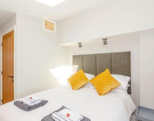 a bedroom with a white bed with yellow pillows at The View at 52, Whitby in Whitby
