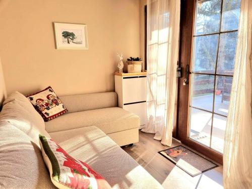 - un salon avec un canapé et une fenêtre dans l'établissement Vila Lucic Zlatibor, à Zlatibor