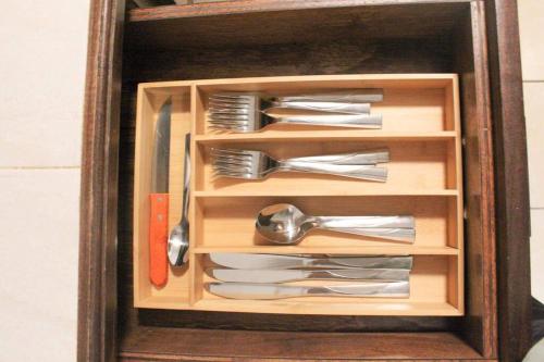 a wooden drawer filled with utensils in a wooden box at Casa Mezquite. In Downtown Brownsville in Brownsville