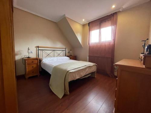a small bedroom with a bed and a window at Apartamento Centro de Llanes in Llanes
