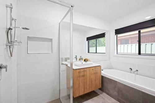 a bathroom with a tub and a sink and a shower at Julie-Anna, Bendigo in Bendigo