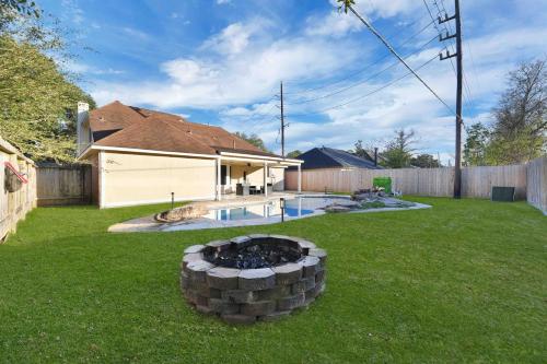a backyard with a fire pit in the grass at My Villa & Pool in Humble in Humble