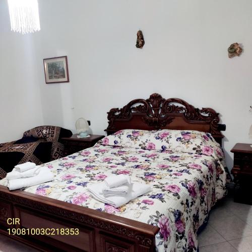 1 Schlafzimmer mit einem Bett mit Blumenbettdecke in der Unterkunft Casa Maiorana in Calatafimi