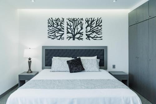 a white bedroom with a large bed with white sheets at Dreams Apartments 8. Loft a 9 minutos de la playa in Isla Mujeres