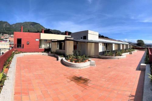 a red building with a red brick courtyard with plants at Comfy loft in La Candelaria in Bogotá