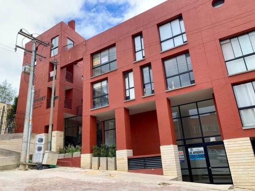 a red brick building with windows on a street at Comfy loft in La Candelaria in Bogotá