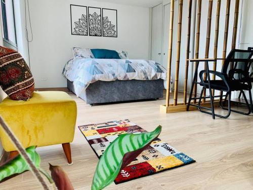 uma sala de estar com uma cama e uma cadeira em Amazing loft in La Candelaria em Bogotá