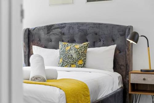 a bedroom with a bed with a gray headboard and pillows at Modern 1 Bed Apt OP MHS in Sydney