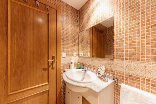 a bathroom with a sink and a mirror at S Valle de incles- Grandvalira free parking in Canillo