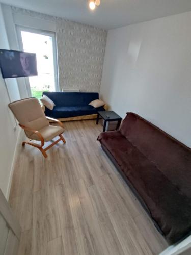 a living room with a couch and a chair at 1120 Śmiałego 41 - Tanie Pokoje w Apartamencie - samodzielne zameldowanie - self check in in Poznań