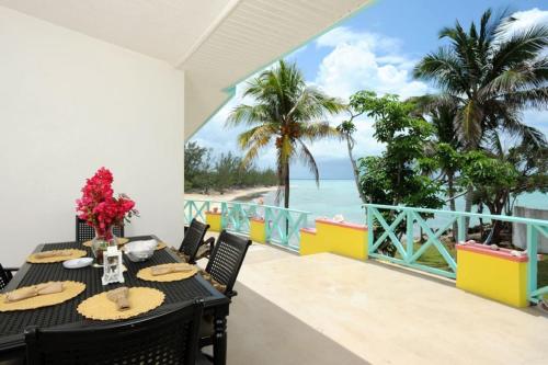 een eetkamer met een tafel en uitzicht op de oceaan bij Pau Pau Beach Estate home in Palmetto Point