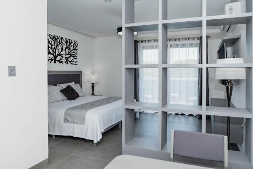 a bedroom with a bed and a window at Dreams Apartments 7. Loft a 9 minutos de la playa in Isla Mujeres