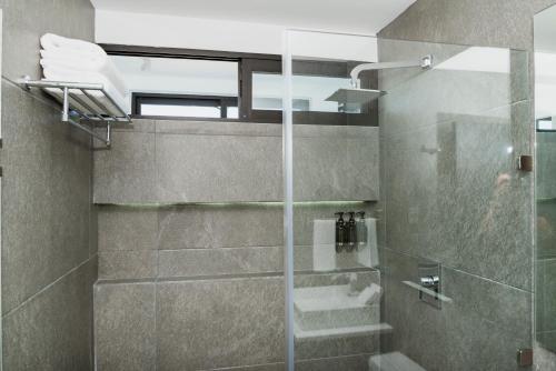 a bathroom with a shower with a glass door at Dreams Apartments 7. Loft a 9 minutos de la playa in Isla Mujeres