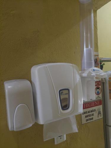um dispensador de papel higiénico branco numa parede em Pousada Aconchego de Mãe em Fortaleza