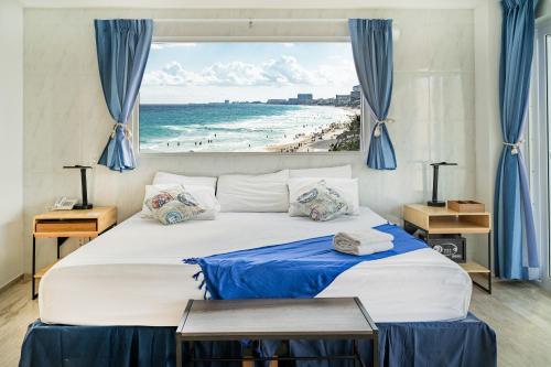 a bedroom with a bed with a view of a beach at Paradise Beachfront & Nightlife Heart in Cancún