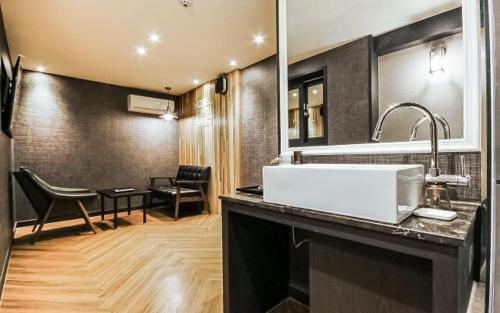 a bathroom with a sink and a dining room at Hotel the Sweet in Busan