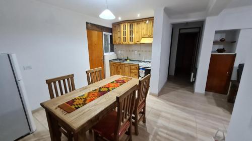 cocina con mesa de madera y sillas de madera en La Casa de Lili en San Rafael