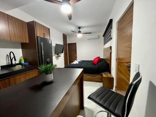 a room with a kitchen and a bedroom with a bed at AHAU Playa in Playa del Carmen