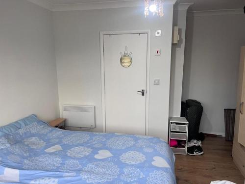 1 dormitorio con 1 cama con edredón azul en HEART OF HANGER LANE en Londres