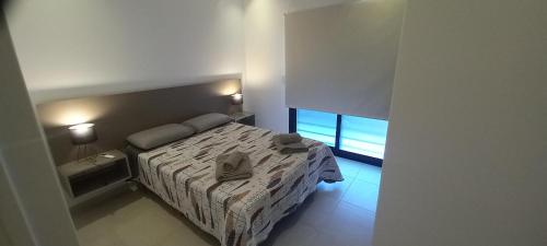 1 dormitorio pequeño con 1 cama y 2 ventanas en Colon Suites 2. Duplex a 18 minutos Aeropuerto Ezeiza en Monte Grande