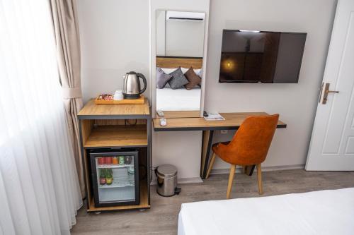 a room with a desk with a bed and a mirror at Comfort Center Suit Hotel in Edirne