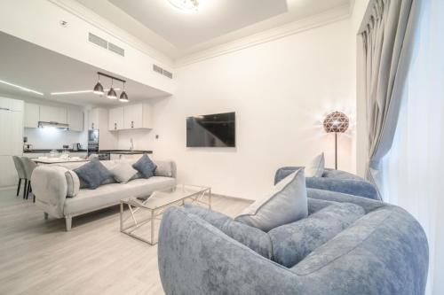 a living room with a blue couch and a kitchen at Boutique Luxury Living near Palm Jumeirah in Dubai