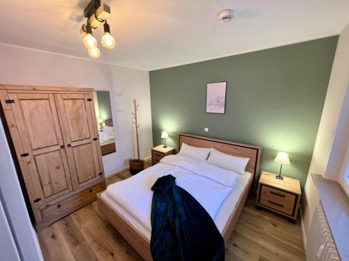 ein Schlafzimmer mit einem Bett und zwei Nachttischen mit zwei Lampen in der Unterkunft Mountain Lodge in Sankt Andreasberg
