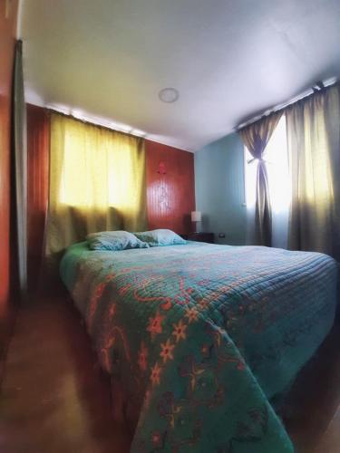 a bedroom with a large bed and a window at departamentos don Pato in Castro
