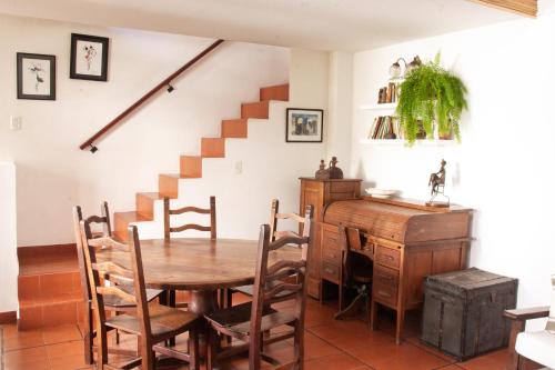 a dining room with a table and a staircase at Calida casa ph, con patio in Florida